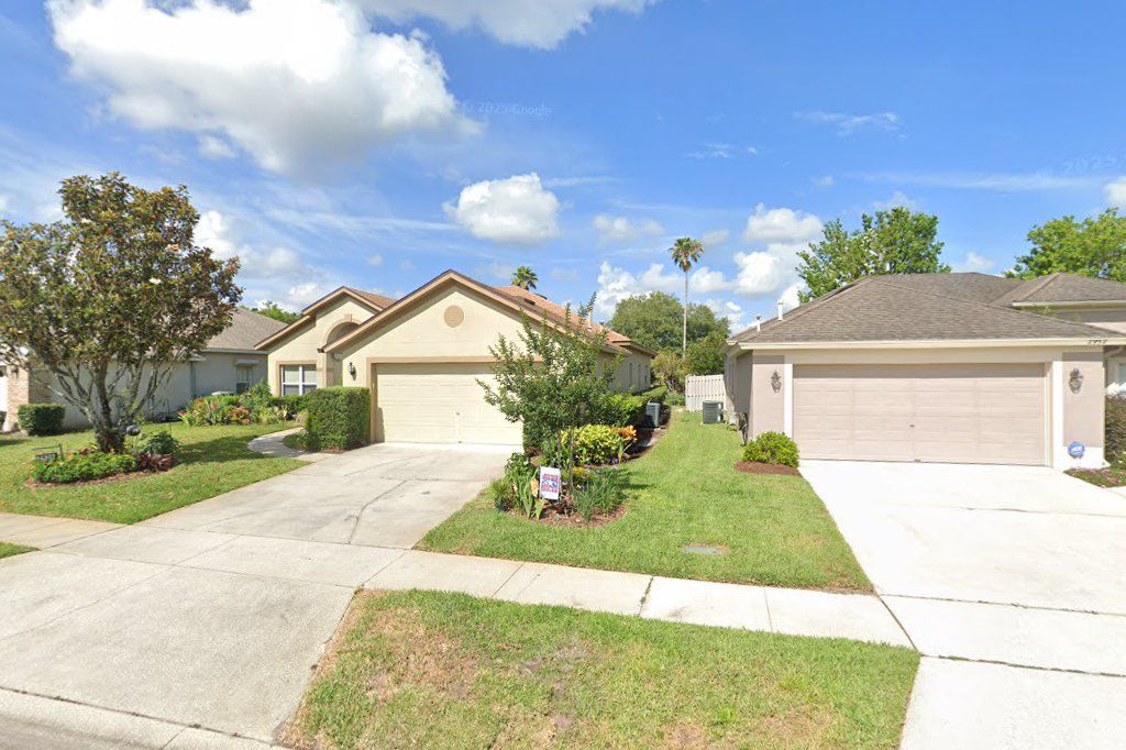 Cream one-story home with a two-car garage on Cedar Glen Place, Oviedo